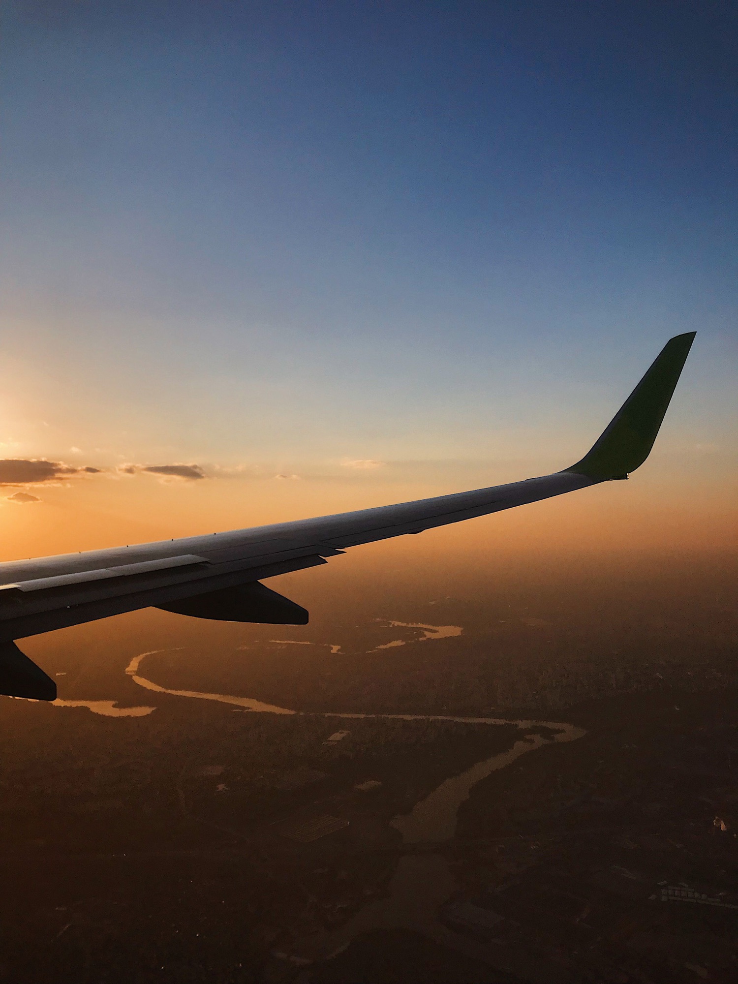 Aile d’avion au coucher du soleil, en route vers le Cambodge