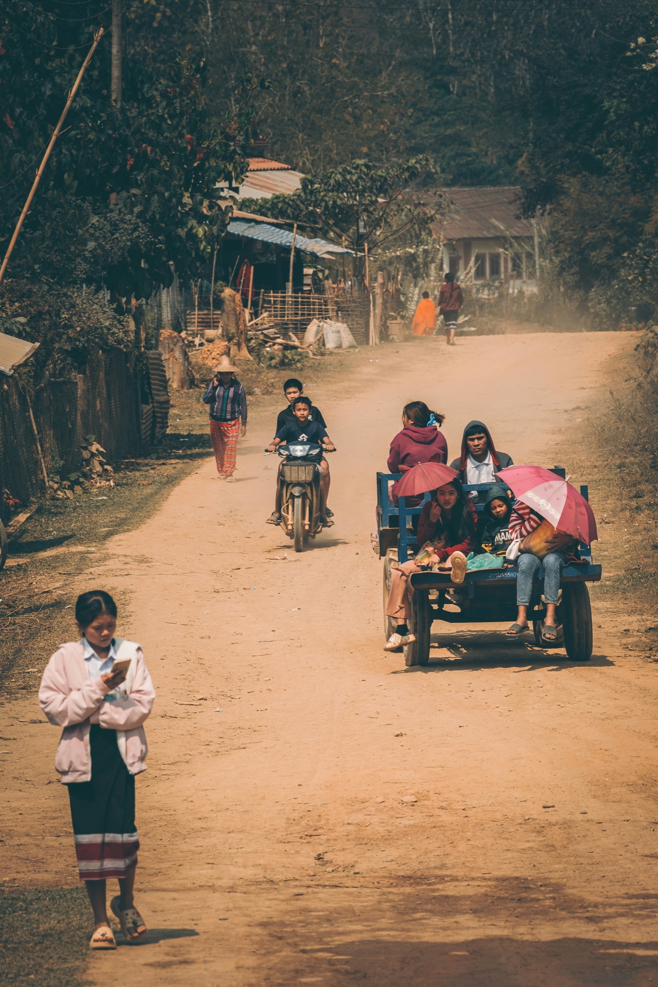 Chemin de village au Laos, enfants et familles au bord d'un sentier ombragé